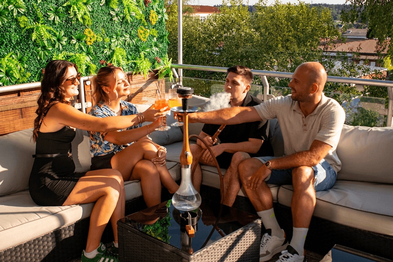 Freunde genießen Shisha und Drinks auf der Panorama-Terrasse der View Lounge